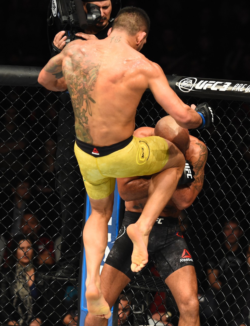 Rafael dos Anjos joga joelhada voadora na cabeça de Robbie Lawler (Foto: Josh Hedges/Getty Images)