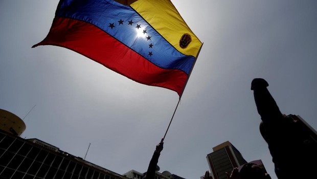 Manifestante empunha bandeira da Venezuela durante marcha contra o governo de Nicolás Maduro em Caracas (Foto: Marco Bello/Reuters)