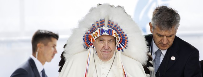 O Papa Francisco usa um cocar tradicional que lhe foi dado por líderes indígenas após seu pedido de desculpas durante sua visita em Maskwacis, Canadá. — Foto: Cole Burston/Getty Images/AFP