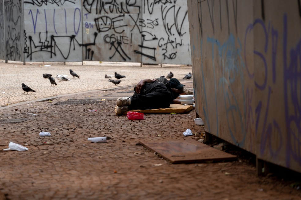 Morador em situação de rua dorme ao lado de tapume no Lardo do Paissandu, Centro de São Paulo, na tarde do dia 8 de janeiro — Foto: Marcelo Brandt/G1