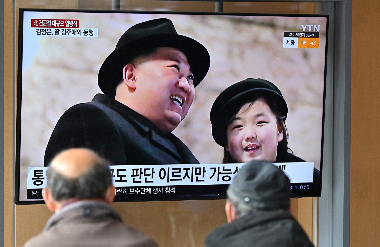 Pessoas assistem a noticiário em 9 de fevereiro de 2023 com imagem do líder norte-coreano Kim Jong-un e sua filha Ju-ae em desfile militar realizado um dia antes pelos 75 anos de fundação das forças armadas do país — Foto: Jung Yeon-je / AFP