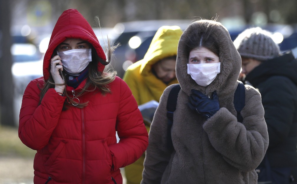 Mulheres usam máscaras contra o novo coronavírus em Minsk, Bielorrússia, nesta sexta-feira (28). — Foto: Sergei Grits/AP