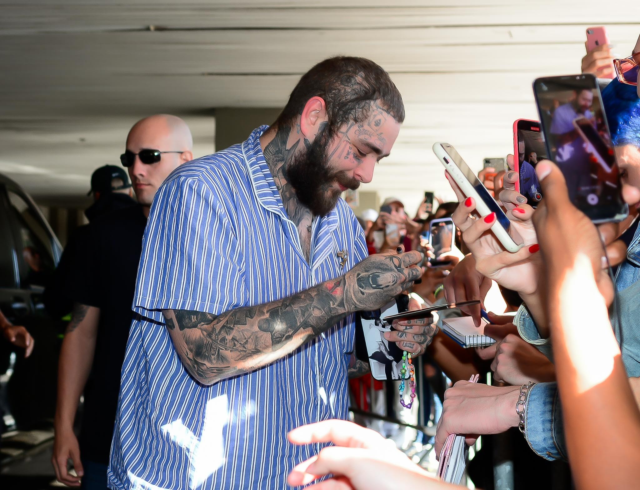 Post Malone desembarca de 'pijama' no Rio e atende fãs no aeroporto 