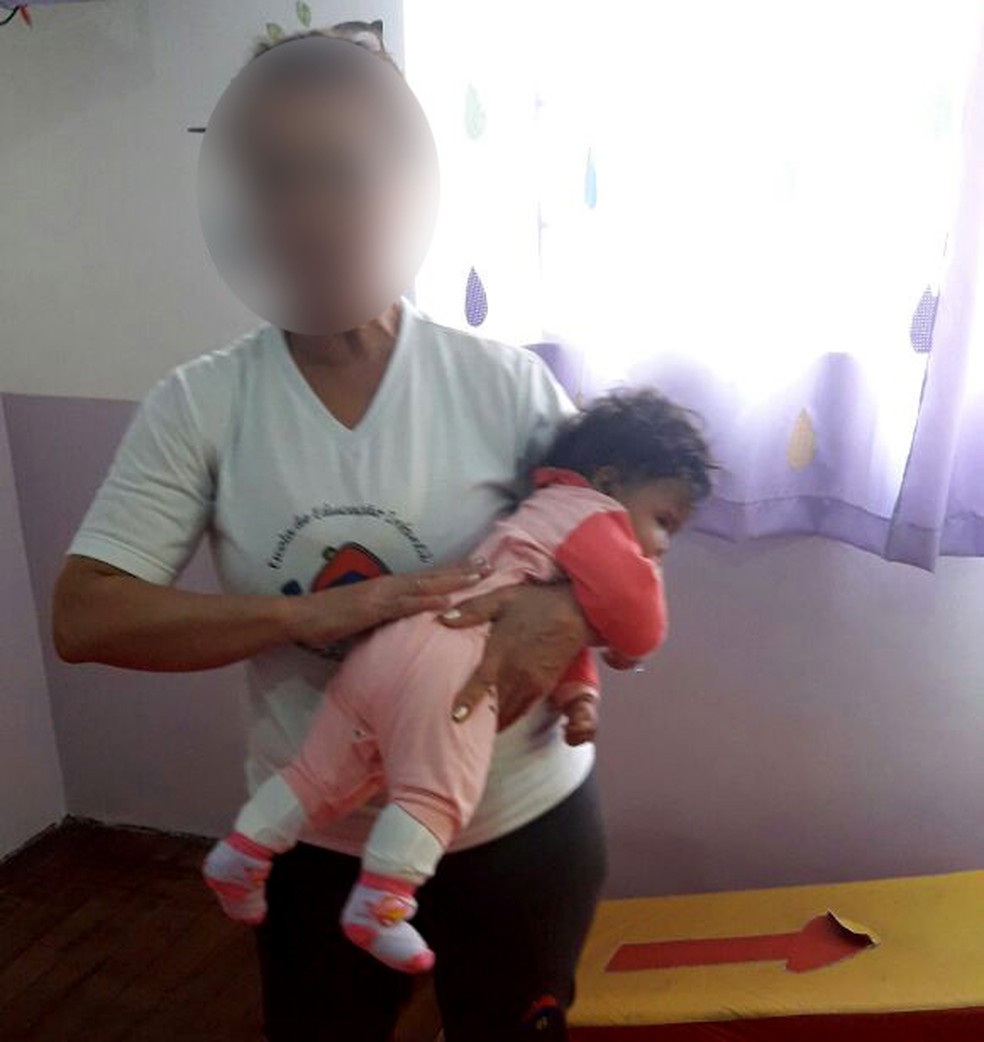 Foto enviada pela escola mostra funcionária da creche em Campinas colocando bebê para dormir (Foto: Devair Maciel / Arquivo pessoal)