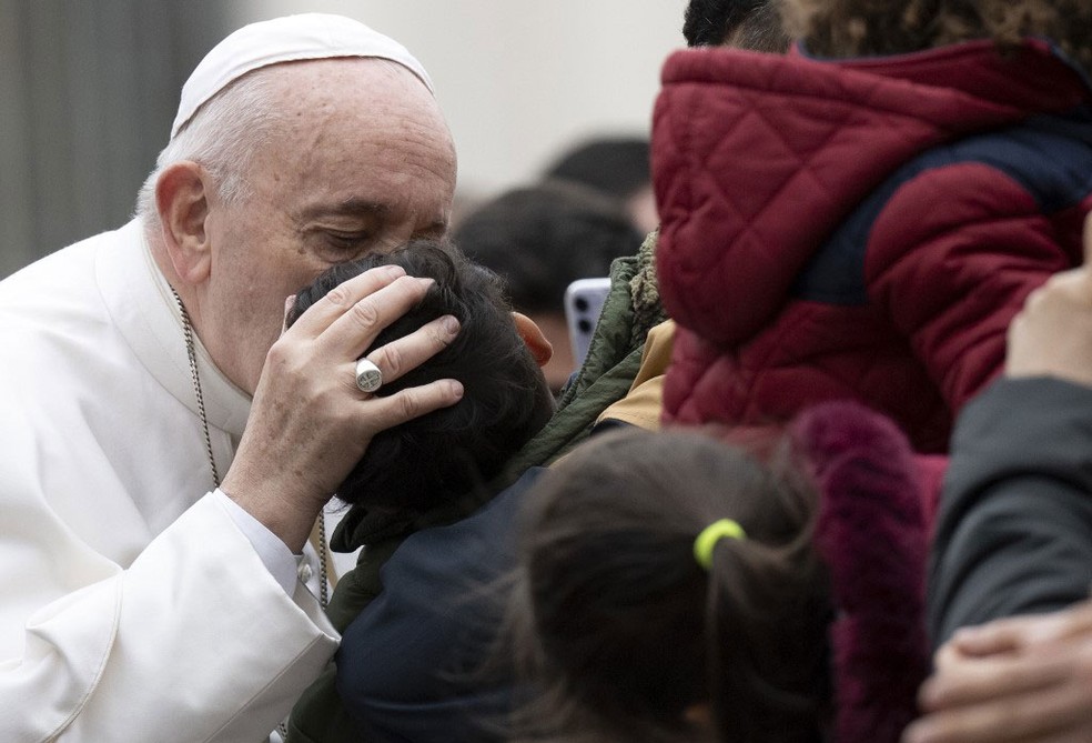 Papa Francisco beija uma criança no fim de sua audiência geral nesta quarta-feira (26)  na praça de São Pedro no Vaticano  — Foto: Tiziana Fabi / AFP