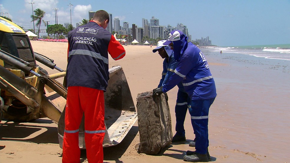 Restroescavadeira foi usada para remover pacote que apareceu na praia em Jaboatão dos Guararapes, no Grande Recife — Foto: Reprodução/TV Globo