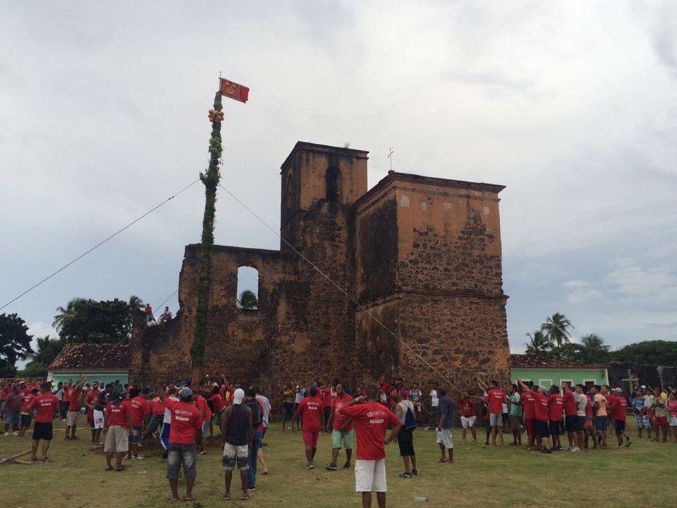 Populares fazem o levantamento do mastro na Festa do Divino, em Alcântara — Foto: Sidney Pereira/ TV Mirante
