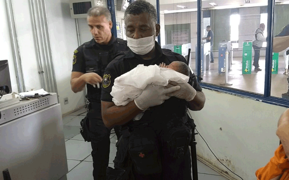 Agente de segurança do Metrô-DF carrega bebê no colo, após parto em estação (Foto: Metrô-DF/Divulgação)
