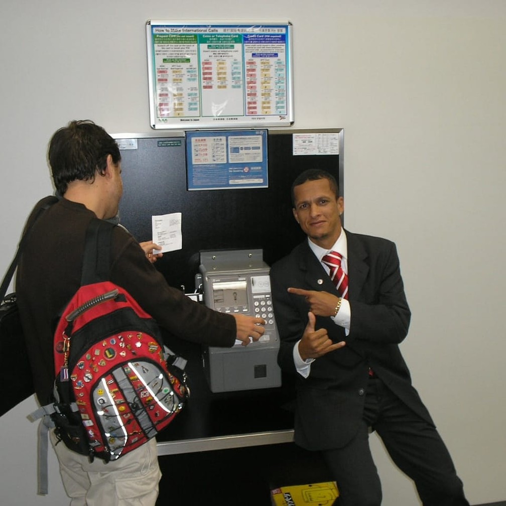 Souza posa ao lado de telefone público no Japão — Foto: Arquivo Pessoal Souza