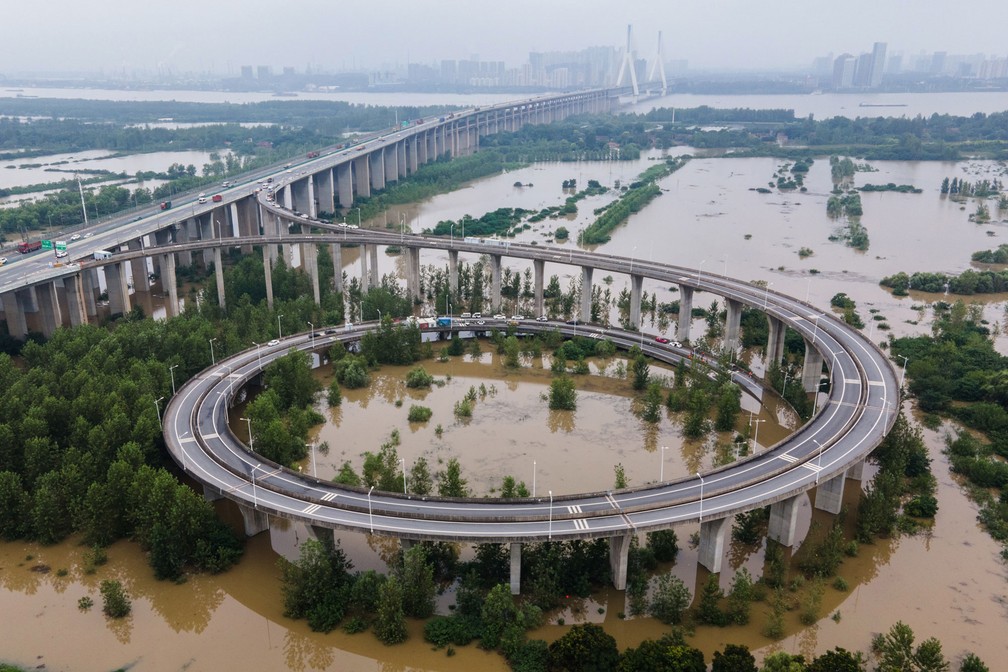 Vista aérea mostra uma ponte que leva à ilha inundada de Tianxingzhou, que deve ser uma zona de fluxo de inundação para aliviar a pressão do alto nível de água no rio Yangtze, em Wuhan, na China, na segunda-feira (13)  — Foto: AFP