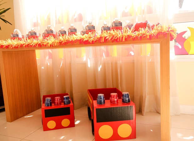 Mesa com carros de bombeiro feitos de papelão foram a lembrancinha da festa (Foto: Arquivo Pessoal)