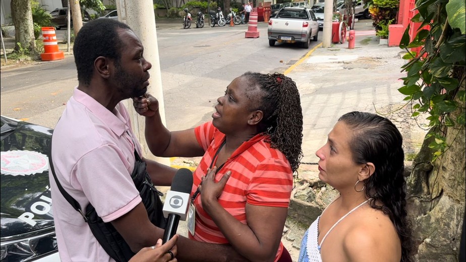 Adriana de Souza Alves, mãe do entregador Max Angelo Alves dos Santos, levanta a cabeça do filho após ele comparecer à 15ª DP (Gávea) nesta quarta-feira