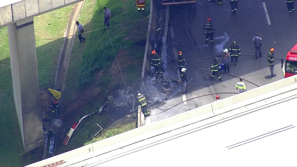 Bombeiros observam o que sobrou do helic&oacute;ptero &mdash; Foto: TV Globo/Reprodu&ccedil;&atilde;o
