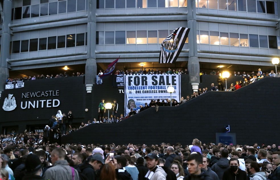Torcedores exibem faixa e comemoram venda do Newcastle para fundo de investimento da Arábia Saudita do lado de fora do estádio St James' Park — Foto: Reuters/Lee Smith