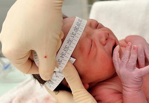 Enfermeira mede a cabeça de criança recém-nascida para verificar sinais de microcefalia (Foto: Reprodução/YouTube)