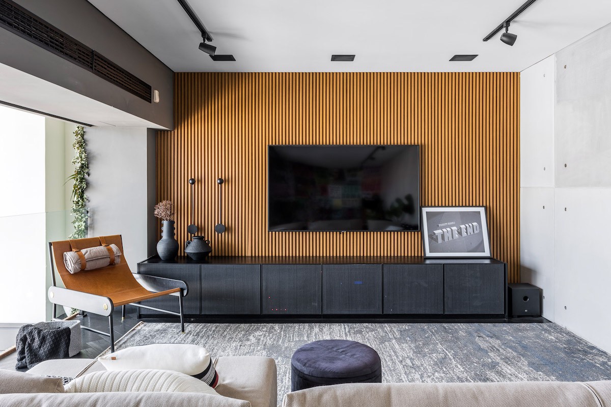 HOME | Do outro lado da parede de lambe lambe está posicionada a TV, e uma poltrona que permite usar o espaço para conversas e encontros (Foto: Divulgação / Renato Navarro )