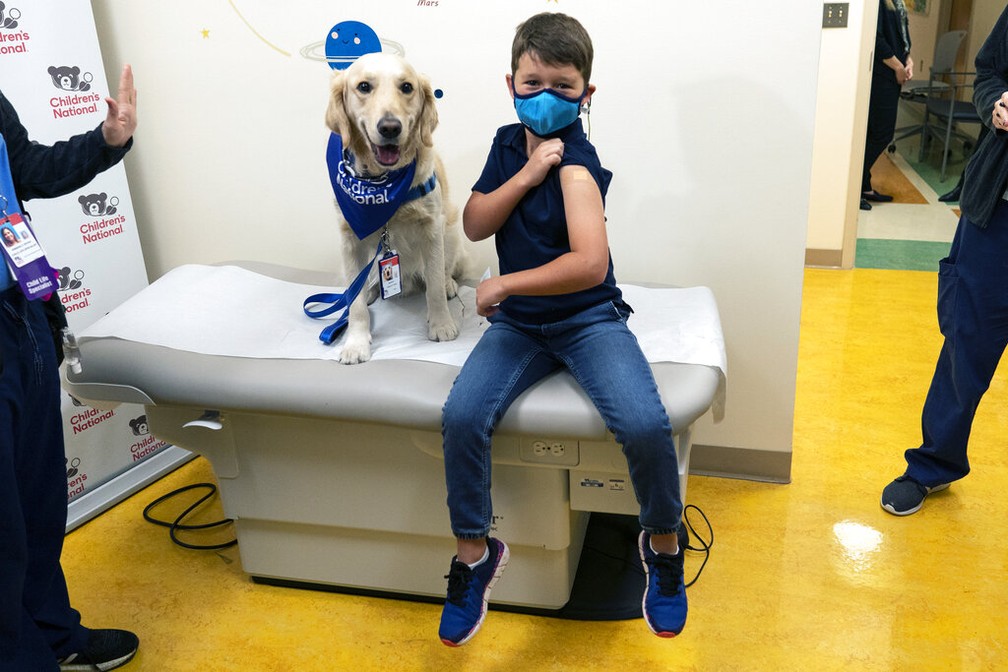 Garoto posa com seu cachorro após vacina nos EUA em 3 de novembro de 2021 — Foto: Carolyn Kaster/AP