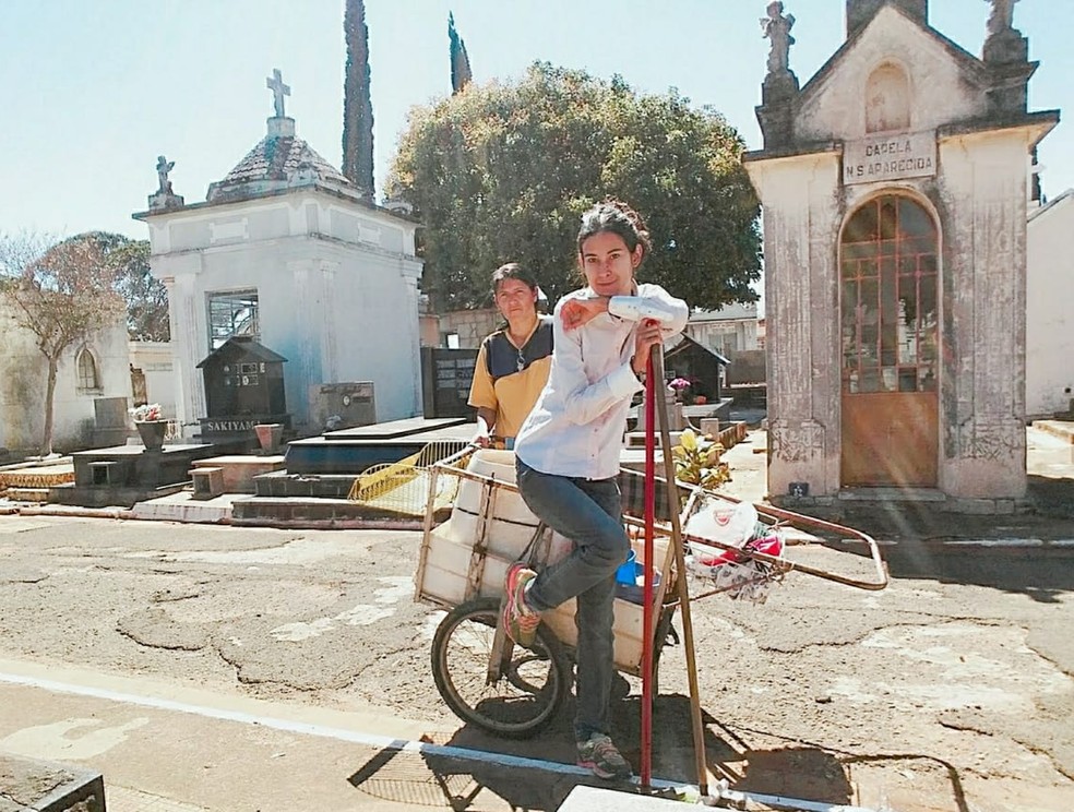 Jaqueline e a mãe junto ao carrinho em que carregam todo material usado na limpeza dos túmulos: tradição de família — Foto: Arquivo pessoal