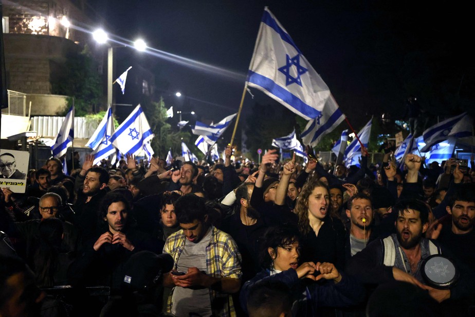 Manifestantes agitam bandeiras de Israel durante protesto contra as reformas judiciais do governo, em Tel Aviv