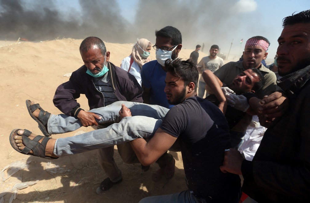 Palestino ferido Ã© transportado nesta terÃ§a-feira (15) durante protesto na Faixa de Gaza (Foto: Ibraheem Abu Mustafa/Reuters)