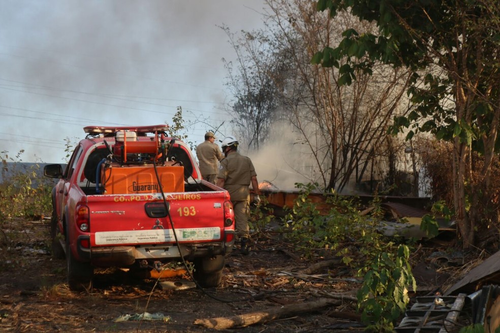 Bombeiros tentam controlar as chamas em sucata — Foto: Stephanie Pacheco