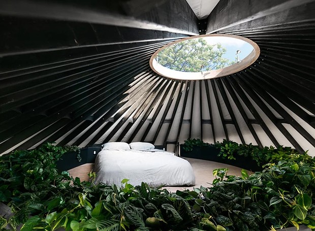 O dormitório é como um oásis: a cama fica cercada por 45 plantas e é banhada pela luz natural vinda de uma claraboia (Foto: Designboom/  bryan aulick/  Reprodução)