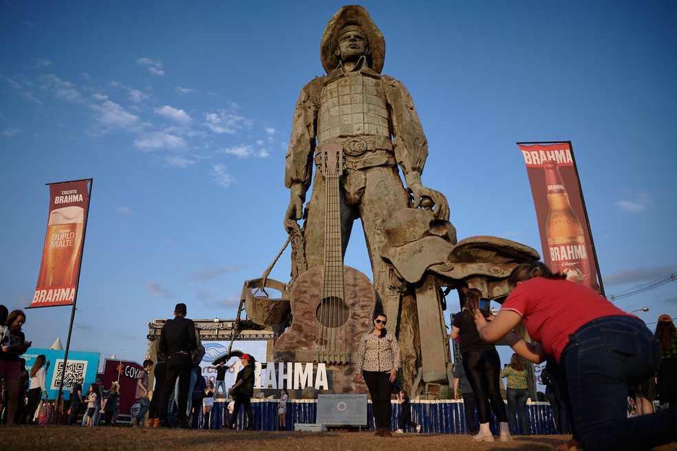 Visitantes do Parque do Peão em Barretos, SP, tiram foto em frente a monumento  — Foto: Igor do Vale/g1