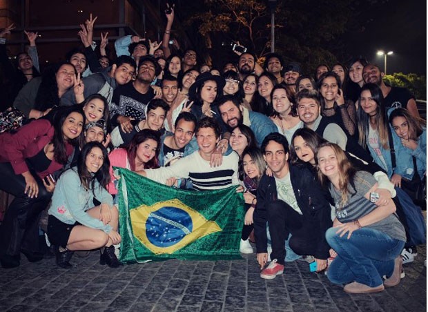 Ansel com fãs e a bandeira do Brasil (Foto: Reprodução Instagram)