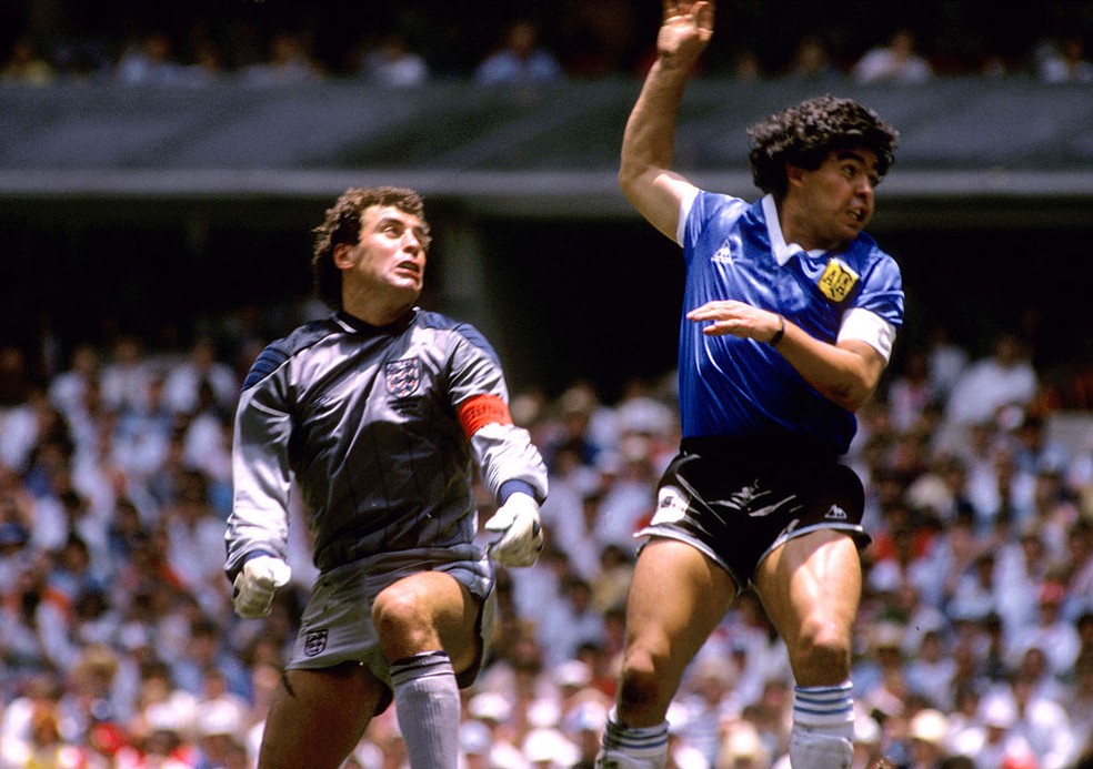 Sob olhares de Shilton, Maradona marca o gol com a "Mão de Deus" na classificação da Argentina sobre a Inglaterra na Copa de 1986 — Foto: Getty Images