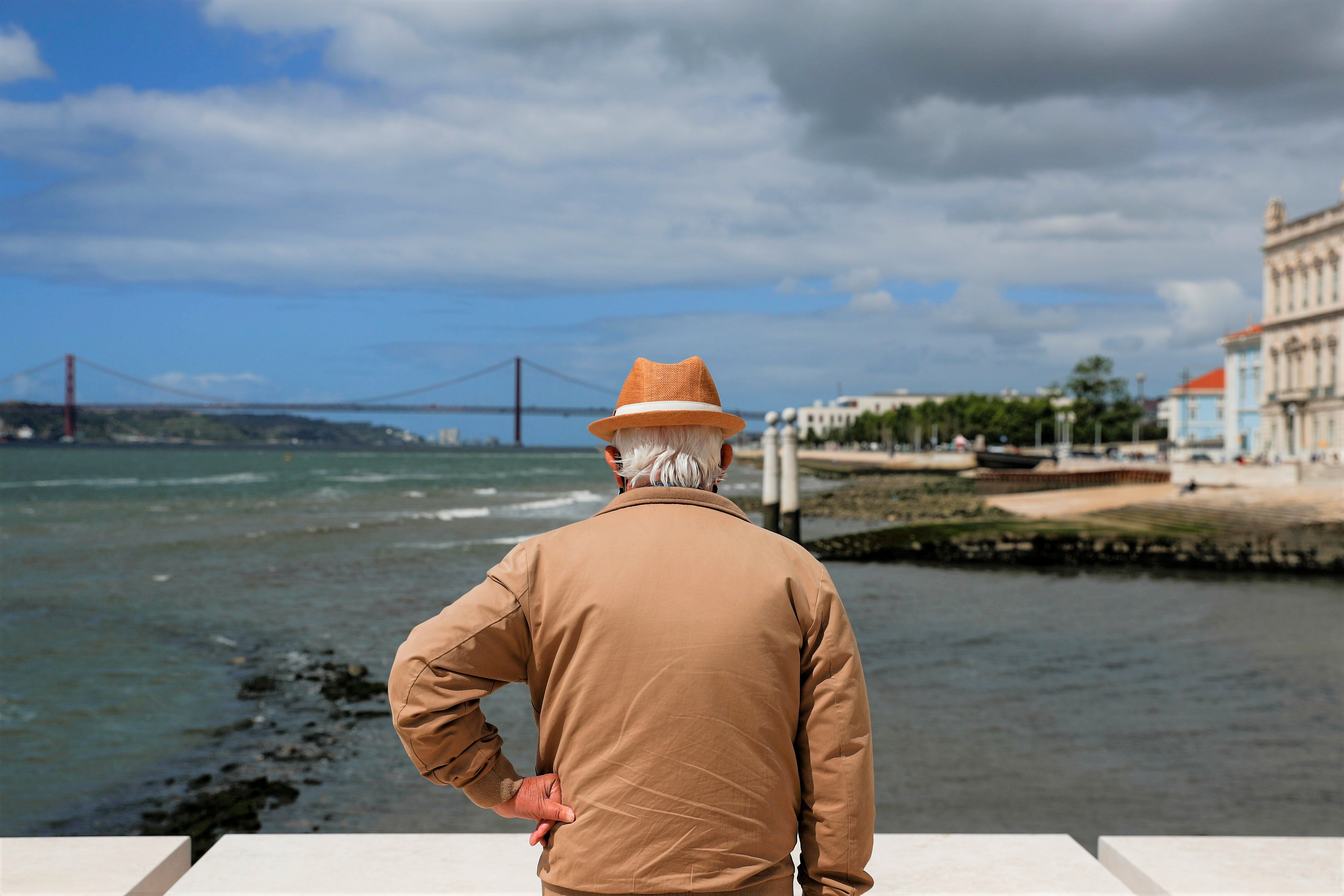Homem observa a Ponte 25 de Abril sobre o Rio Tejo em Lisboa