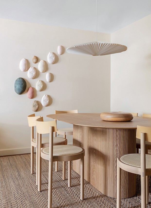 Cadeiras Gravatá, da Wentz Design, e mesa TromsØ, da Wooding, compõem a sala de jantar, com pendente de Mel Kawahara. Na parede, as cerâmicas de Rosalva Siqueira resumem a paleta do apê (Foto: Maura Mello / Divulgação)