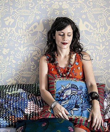 Joana Lira em sua casa, que tem papel de parede e almofadas com estampas criadas por ela (Foto: Mayra Azzi/ Editora Globo)