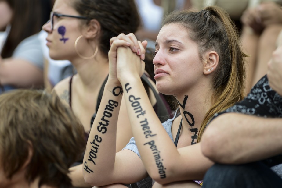 Mulher chora após ouvir relatos de mulheres vítimas de violência doméstica durante Marcha das Mulheres em Curitiba, em 8 de março de 2019