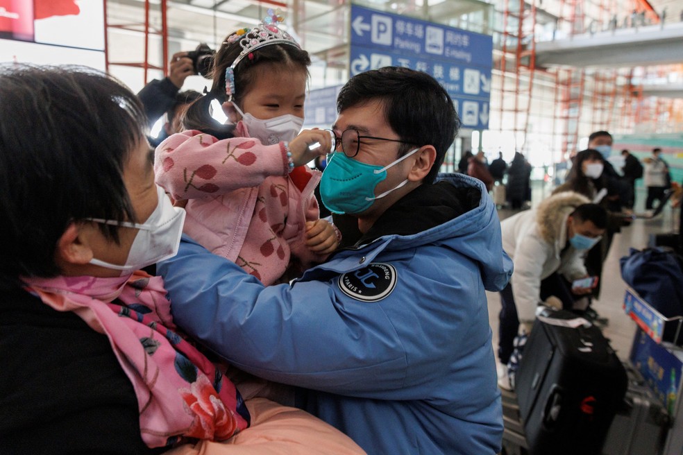 Familiares se abraçam no portão de desembarque internacional do Aeroporto Internacional da Capital de Pequim  — Foto: REUTERS/Thomas Peter