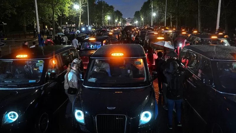 Tradicionais táxis pretos de Londres fazem fila em homenagem na avenida que leva ao palácio de Buckingham (Foto: GETTY IMAGES via BBC)