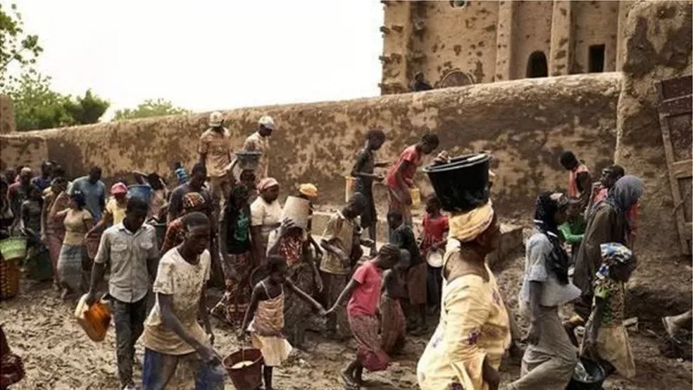 A recobertura anual com argila da Grande Mesquita de Djenné, no Máli, é considerada um importante símbolo de coesão social — Foto: GETTY