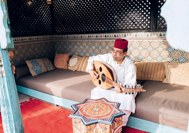 Em festa armada na casa de Marrakech, o músico, e fiel habitué de Adriana, Abdelatif toca OUD, um instrumento usado em ocasiões especiais em Marrocos. (Foto: German Larkin e Acervo pessoal)