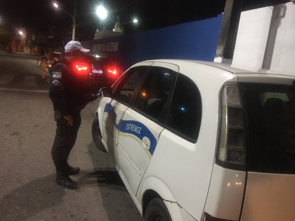 Policial realiza teste do "bafômetro" em motorista de táxi no bairro Alecrim, em Natal. — Foto: Cedida
