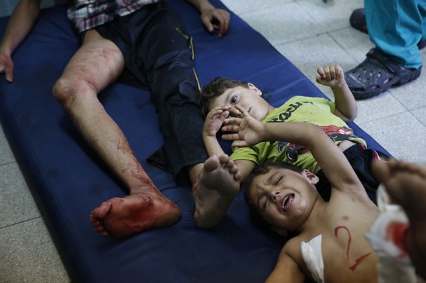 Crianças e homem ferido são vistos após ataque a escola da ONU em Beit Hanoun, no norte da Faixa de Gaza, nesta quinta-feira (24) (Foto: Lefteris Pitarakis/AP)