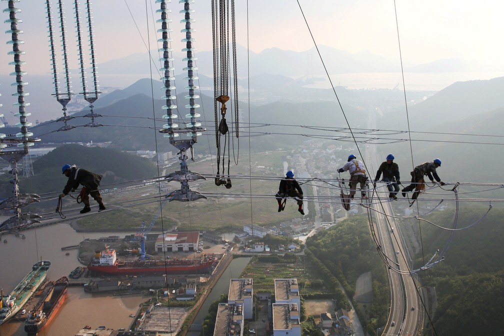 17 de outubro â Homens trabalham em cabos de torres de transmissÃ£o de energia em Zhoushan, na provÃ­ncia de Zhejiang, na China â Foto: Reuters