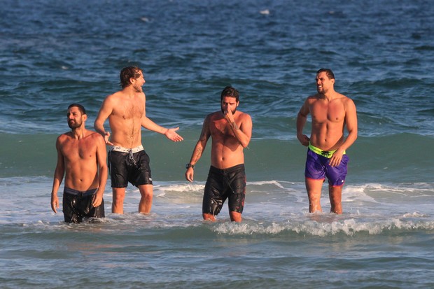 Felipe Roque (de bermuda roxa) curte praia com amigos (Foto: Fabricio Pioyani/AgNews)