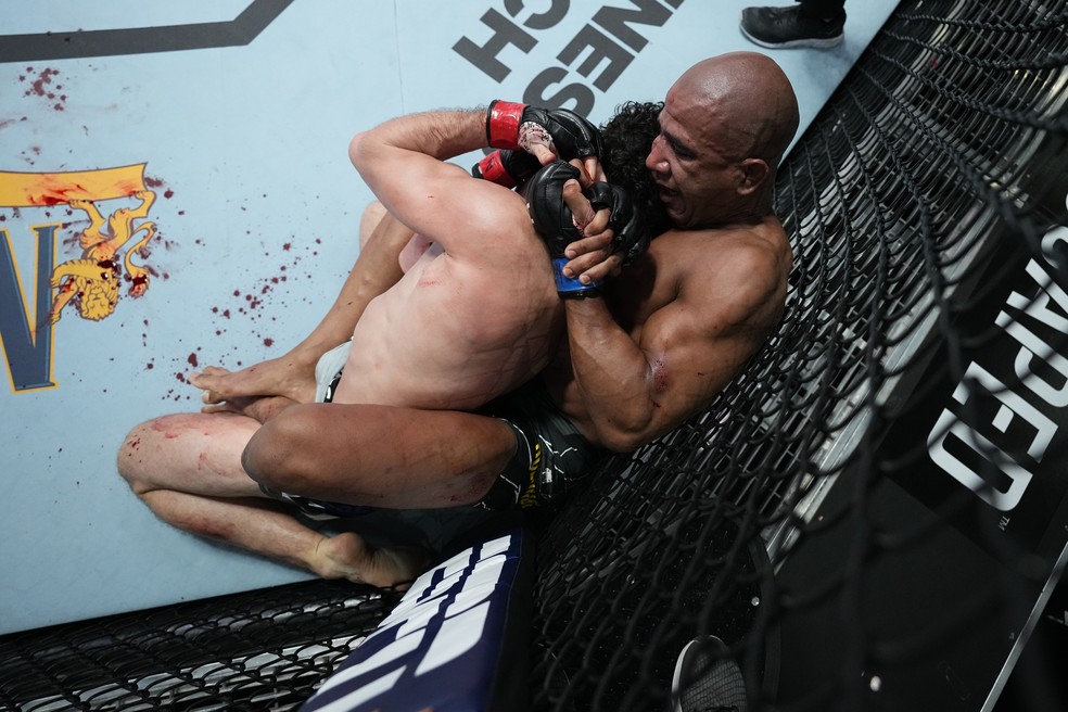 Gregory Robocop encaixa um estarngulamento e quase finaliza Armen Petrosyan no terceiro round — Foto: Chris Unger/Zuffa LLC/Getty Images