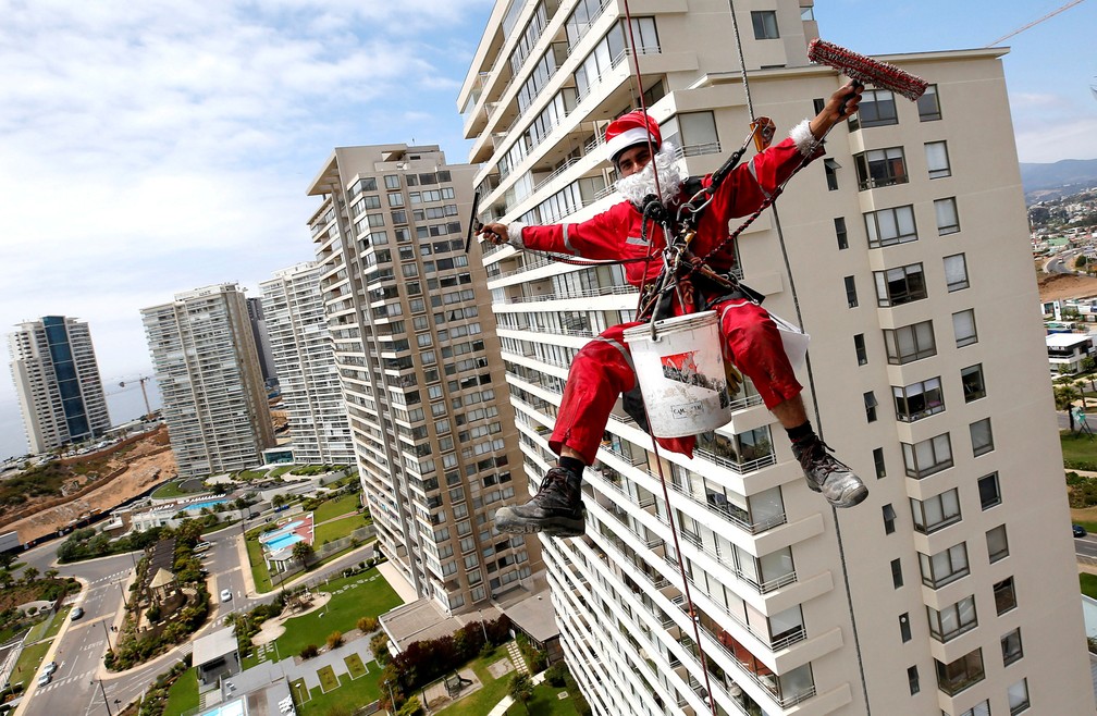22 de dezembro â Um limpador de vidros acena enquanto trabalha vestido de Papai Noel, em Concon, no Chile â Foto: Rodrigo Garrido/Reuters