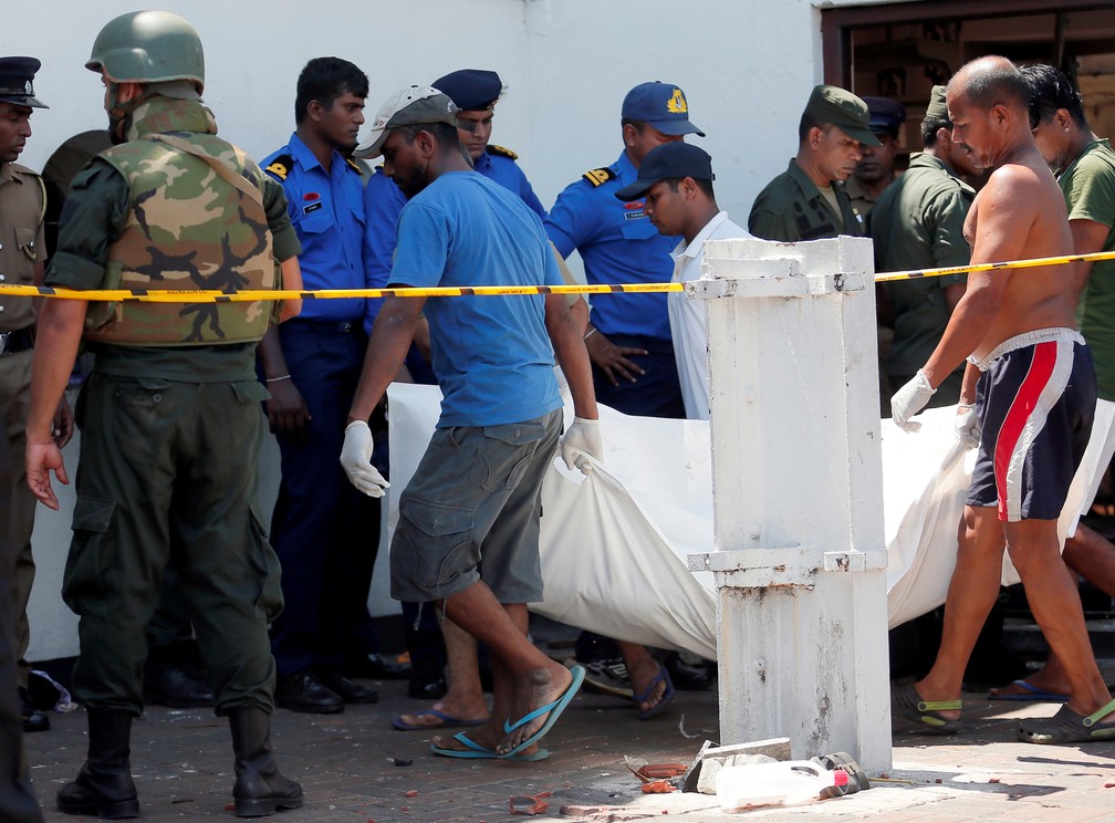 Homens carregam corpo de vÃ­tima da explosÃ£o em igreja â€” Foto: Dinuka Liyanawatte/Reuters