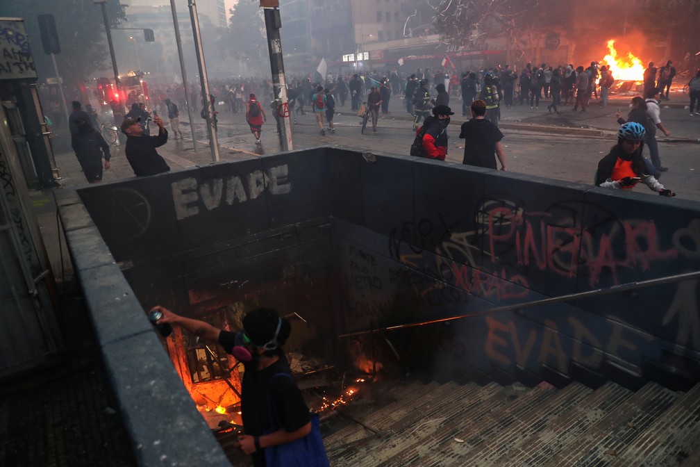 Manifestantes incendeiam passagem subterrânea em Santiago nesta segunda-feira (28), novo dia de protestos no Chile — Foto: Edgard Garrido/Reuters