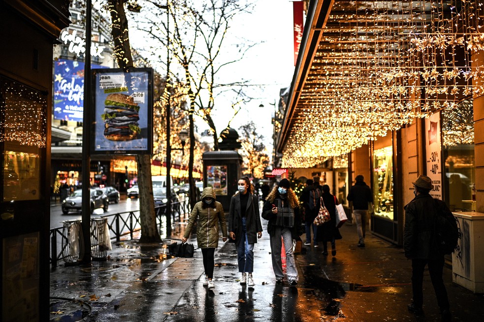 Pessoas passam em frente a uma loja de departamentos em Paris em 23 de dezembro de 2020 — Foto: Christophe Archambault/AFP