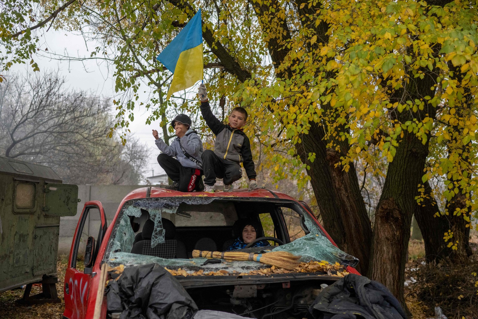 Menino agita bandeira ucraniana em antigo posto de controle russo em Kherson, cidade recuperada pelos Ucranianos — Foto: AFP