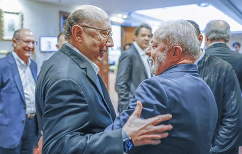 O ex-ministro Henrique Meirelles (esq.) com Lula durante evento em São Paulo