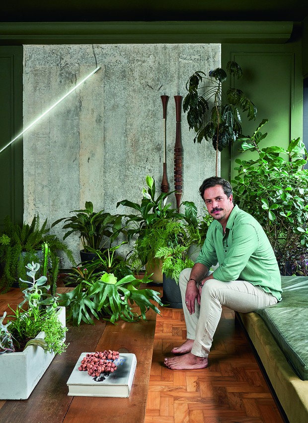 O arquiteto Ricardo Abreu senta-se no sofá Aga II, de Brunno Meireles, feito de mármore, couro e lona verdes (Foto: Renato Navarro / Divulgação)