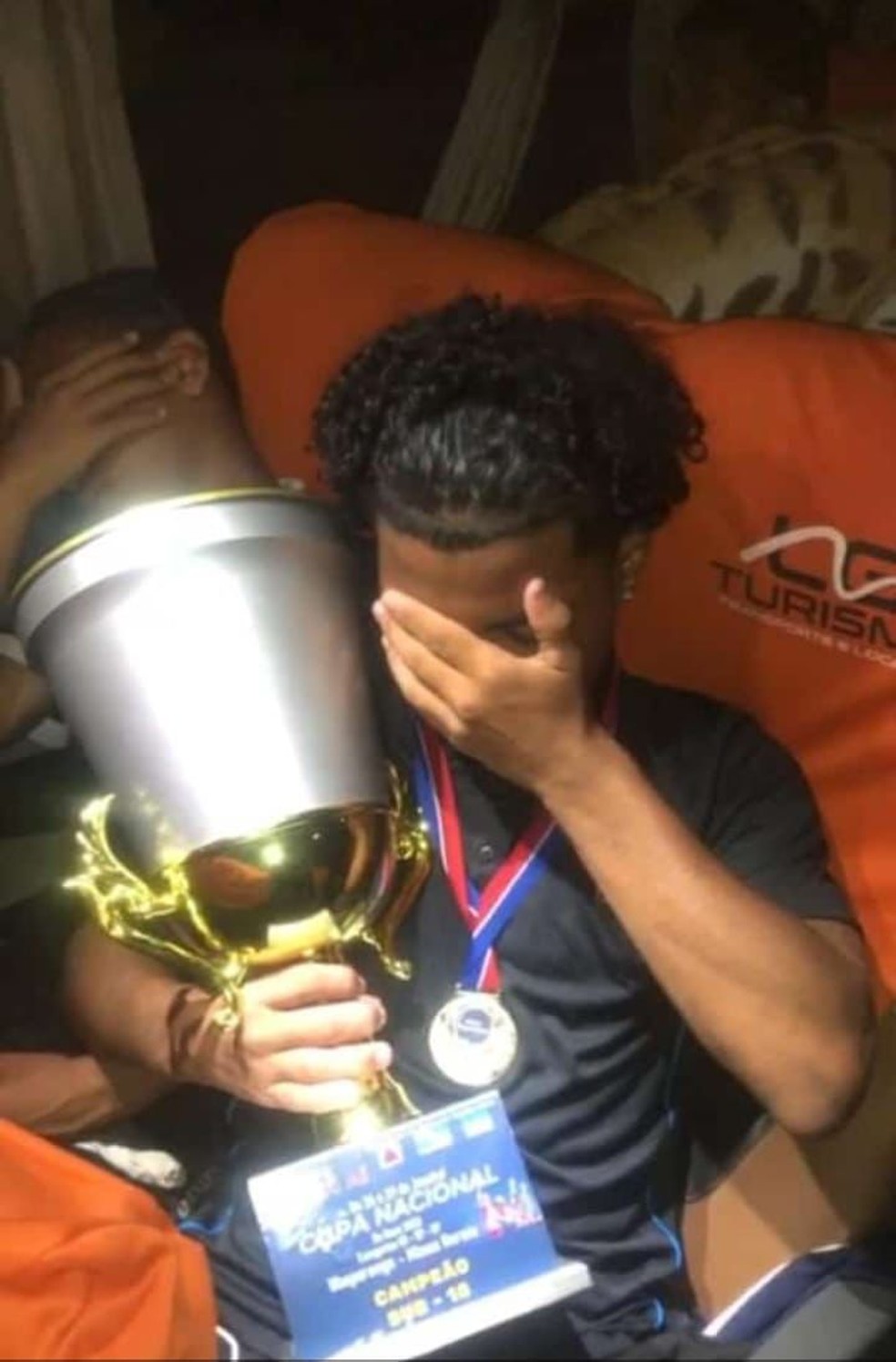  Luan Paiva da Silva, que sobreviveu ao acidente de ônbus, com troféu que o time de Caxias ganhou — Foto: Reprodução